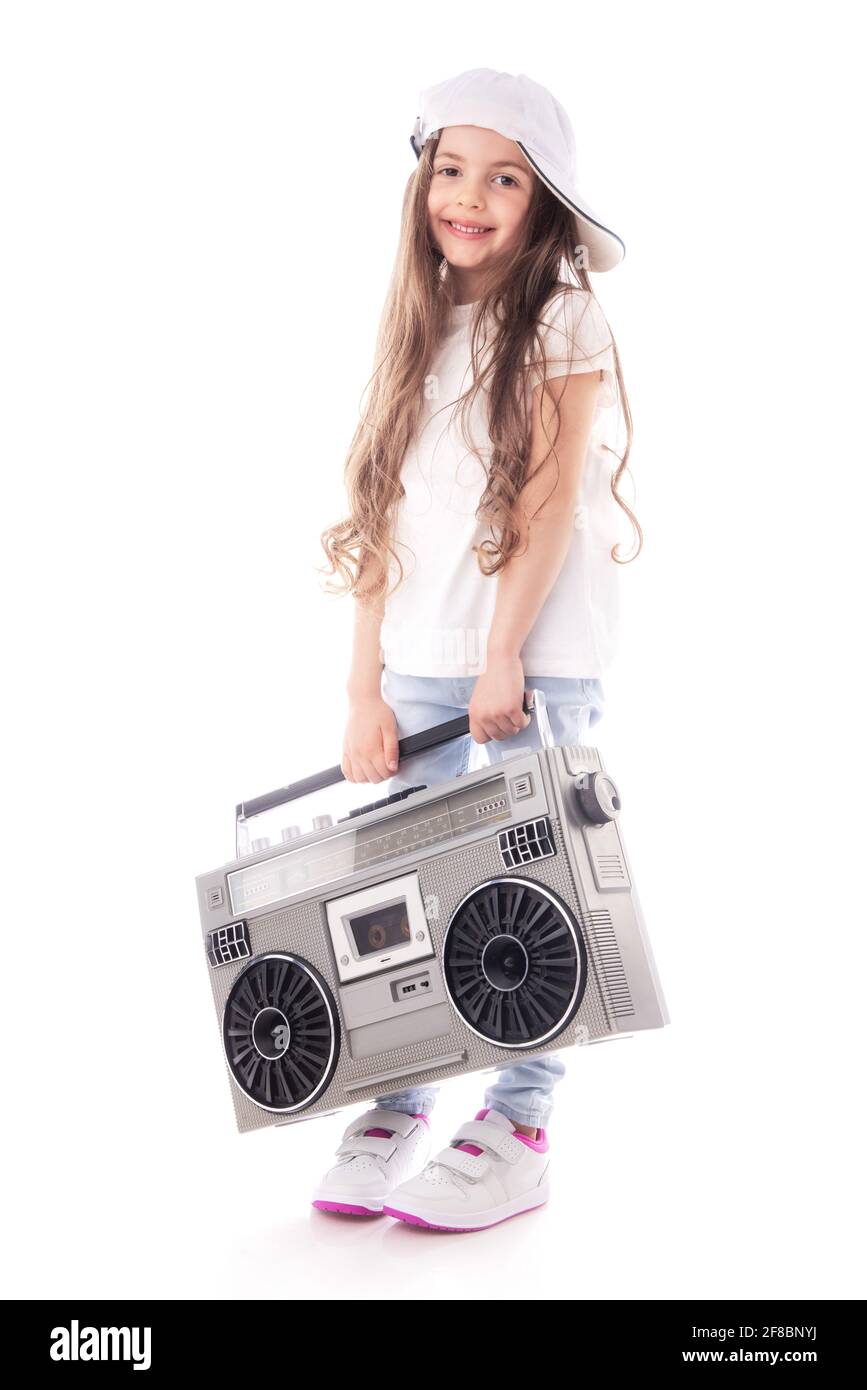 Young hip hop girl listening music on boombox retro radio, ghetto blaster, isolated on white background Stock Photo