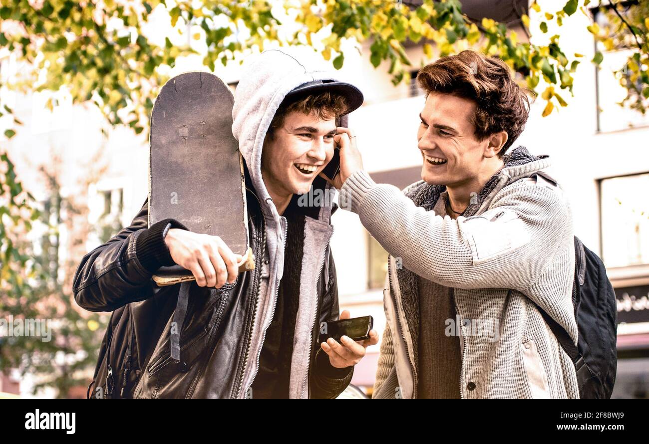 Young happy brothers having fun using mobile smart phones - Best friends sharing free time with new trends technology - Friendship concept Stock Photo