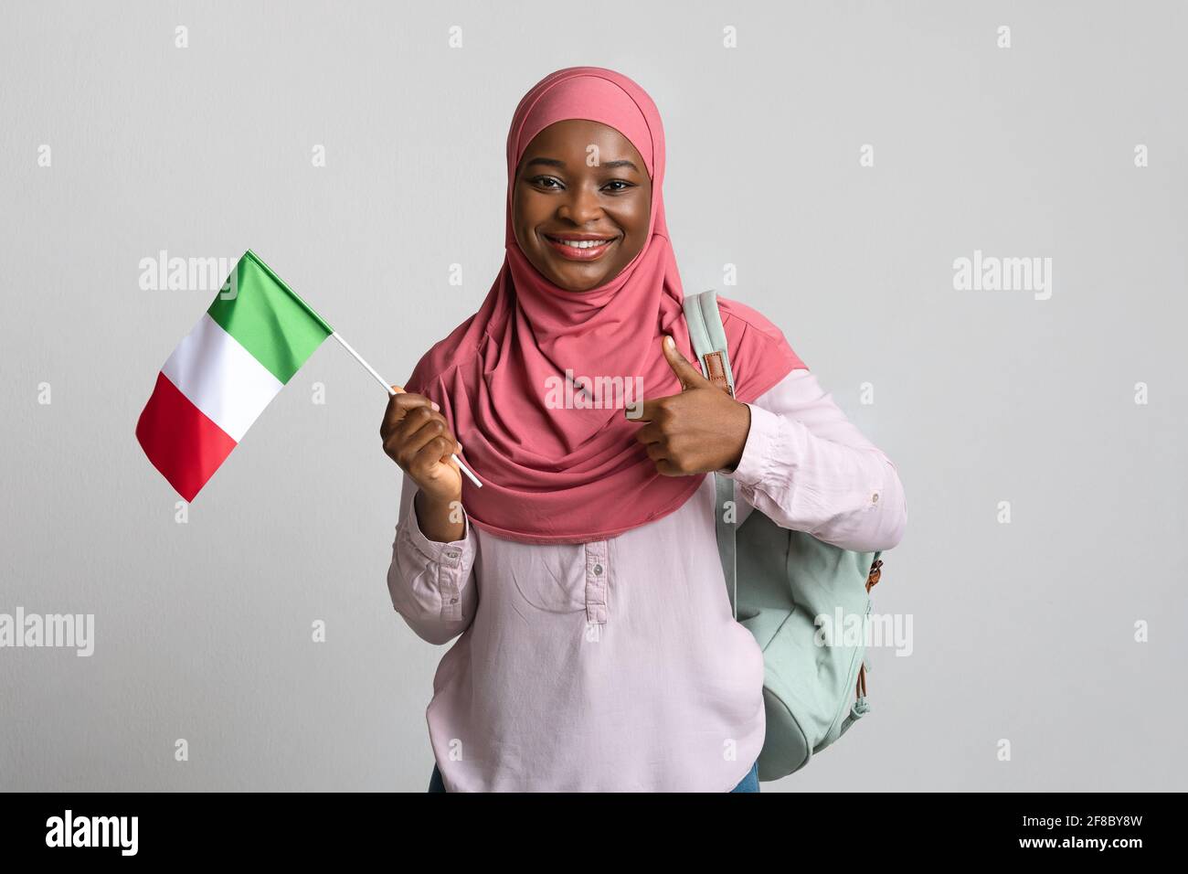Happy african american lady in hijab showing Italian flag Stock Photo