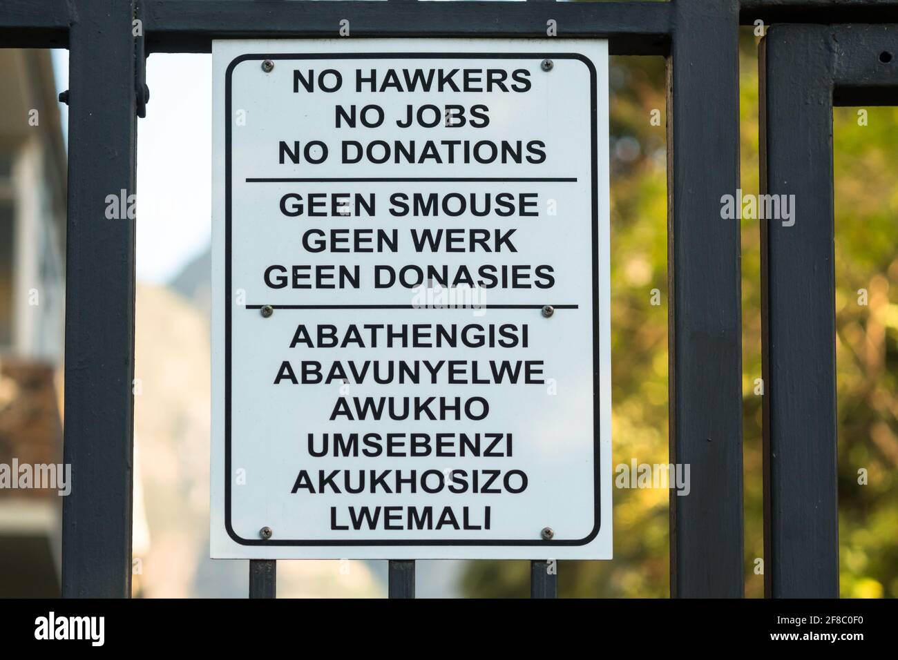 no hawkers, no jobs, no donations sign on a gate in English, Afrikaans and Xhosa, concept recession and economic hardship in South Africa Stock Photo