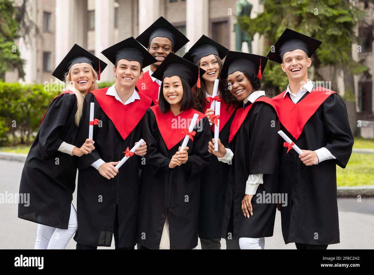 Multicultural Graduation Photo Cheerful multiracial students celebrating graduation, smiling at camera ...