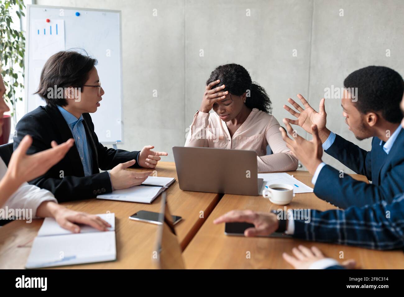 Aggressive Coworkers Shouting At Female Worker After Business Failure Indoors Stock Photo