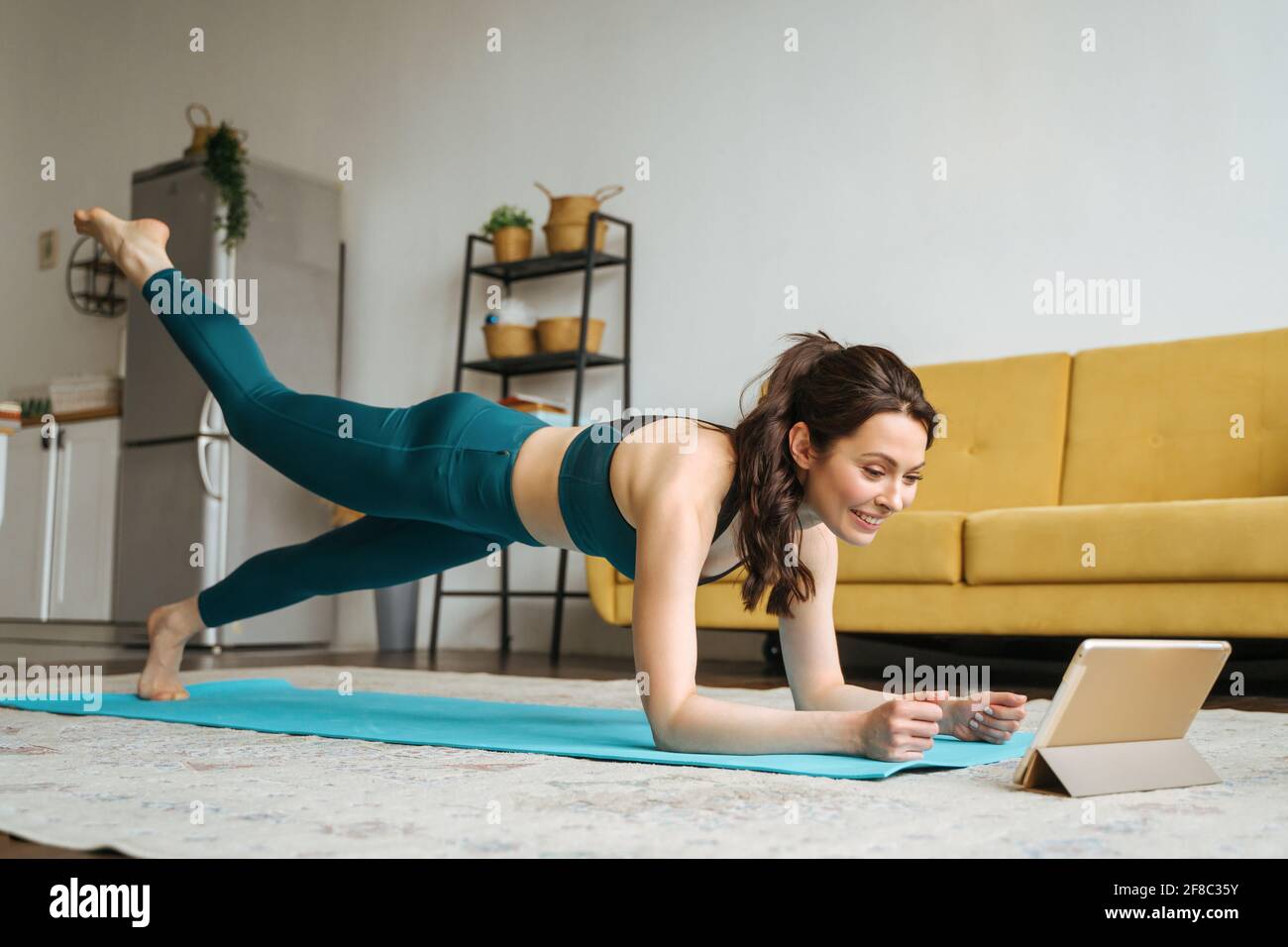 Young woman is engaged in fitness at home. Stock Photo