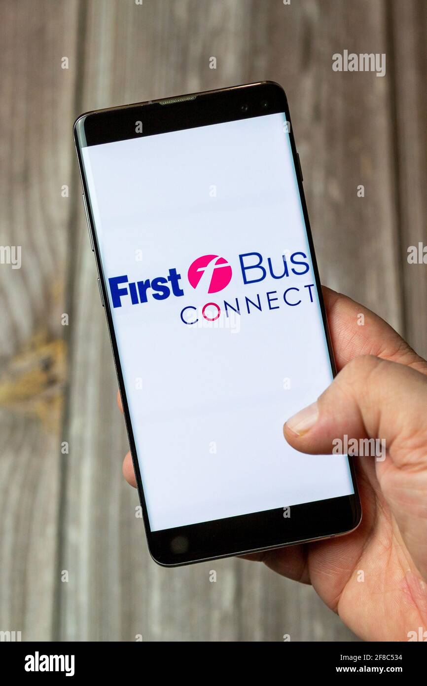 A Mobile phone or cell phone being held in a hand with the First bus connect app open on screen Stock Photo
