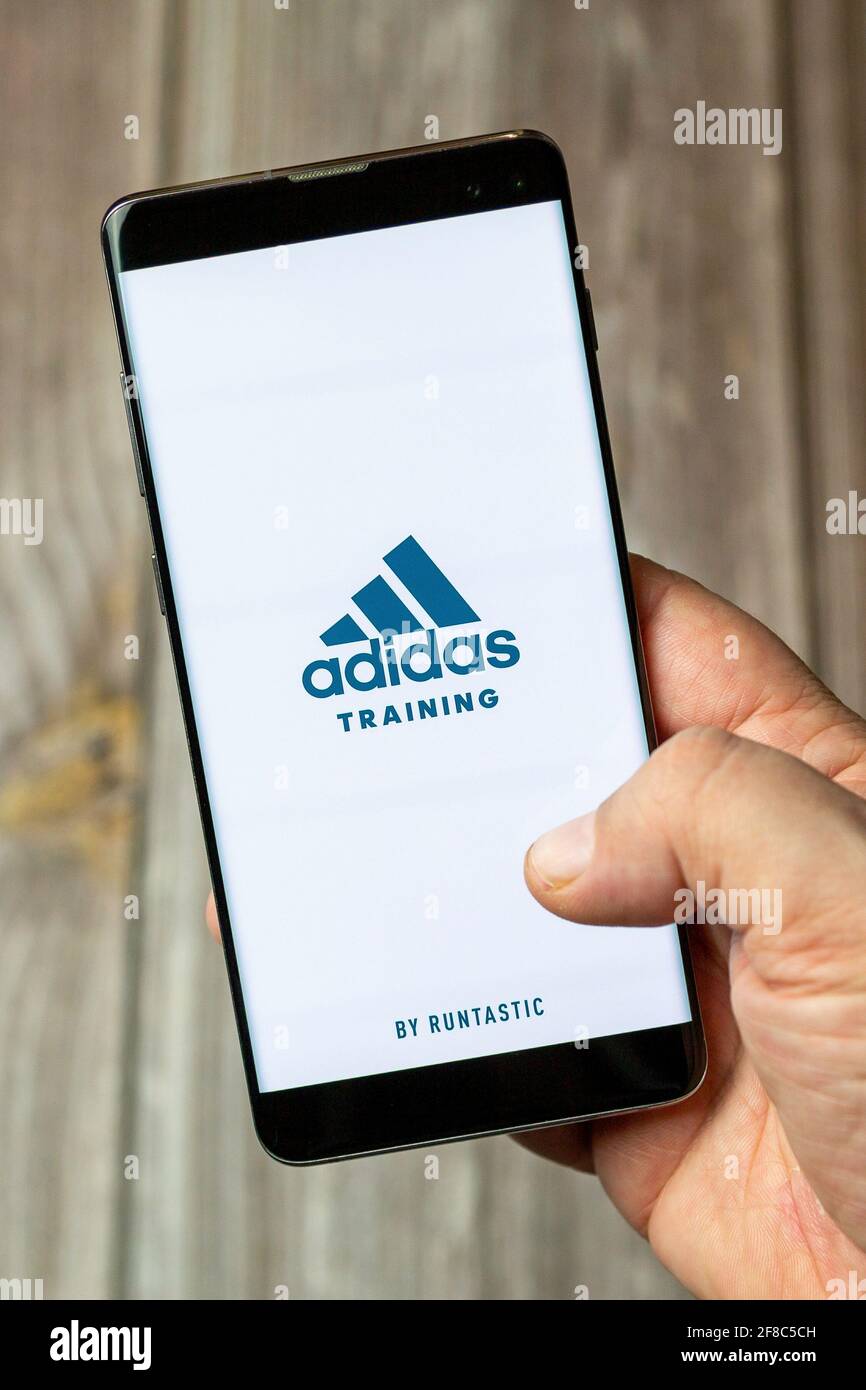 A Mobile phone or cell phone being held in a hand with the Adidas training  app open on screen Stock Photo - Alamy