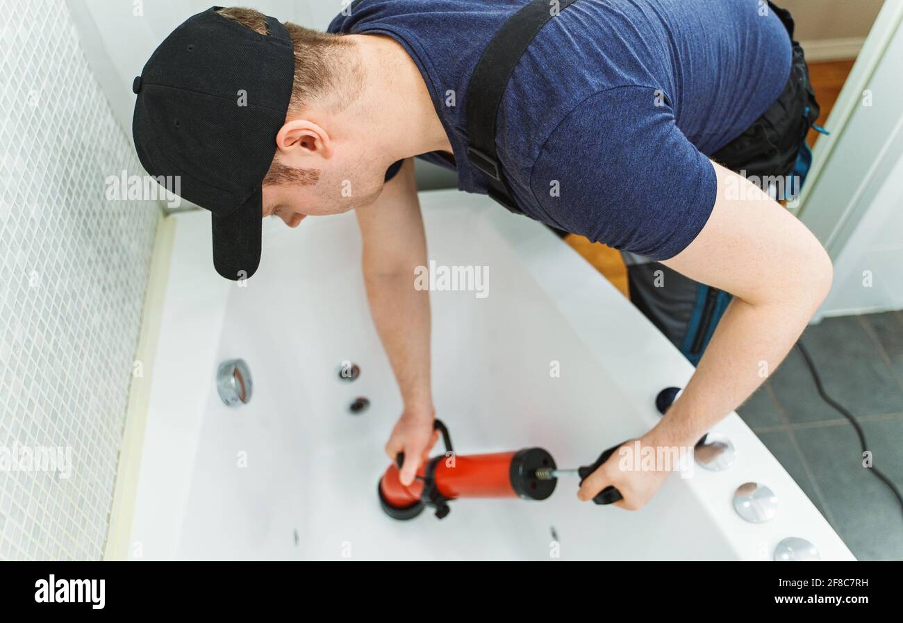 https://c8.alamy.com/comp/2F8C7RH/plumber-unclogging-bathtub-with-professional-force-pump-cleaner-2F8C7RH.jpg