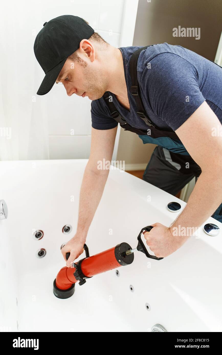 https://c8.alamy.com/comp/2F8C815/plumber-unclogging-bathtub-with-professional-force-pump-cleaner-2F8C815.jpg