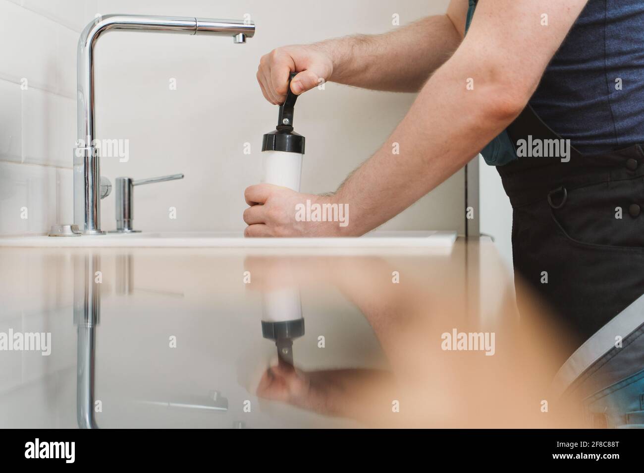 https://c8.alamy.com/comp/2F8C88T/plumber-unclogging-kitchen-sink-with-professional-force-pump-cleaner-2F8C88T.jpg