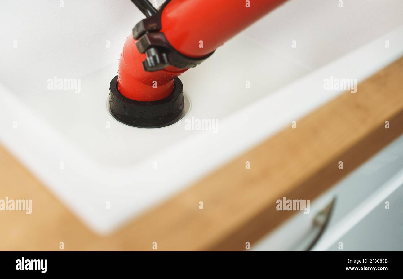 Professional force pump cleaner in the kitchen sink. Stock Photo
