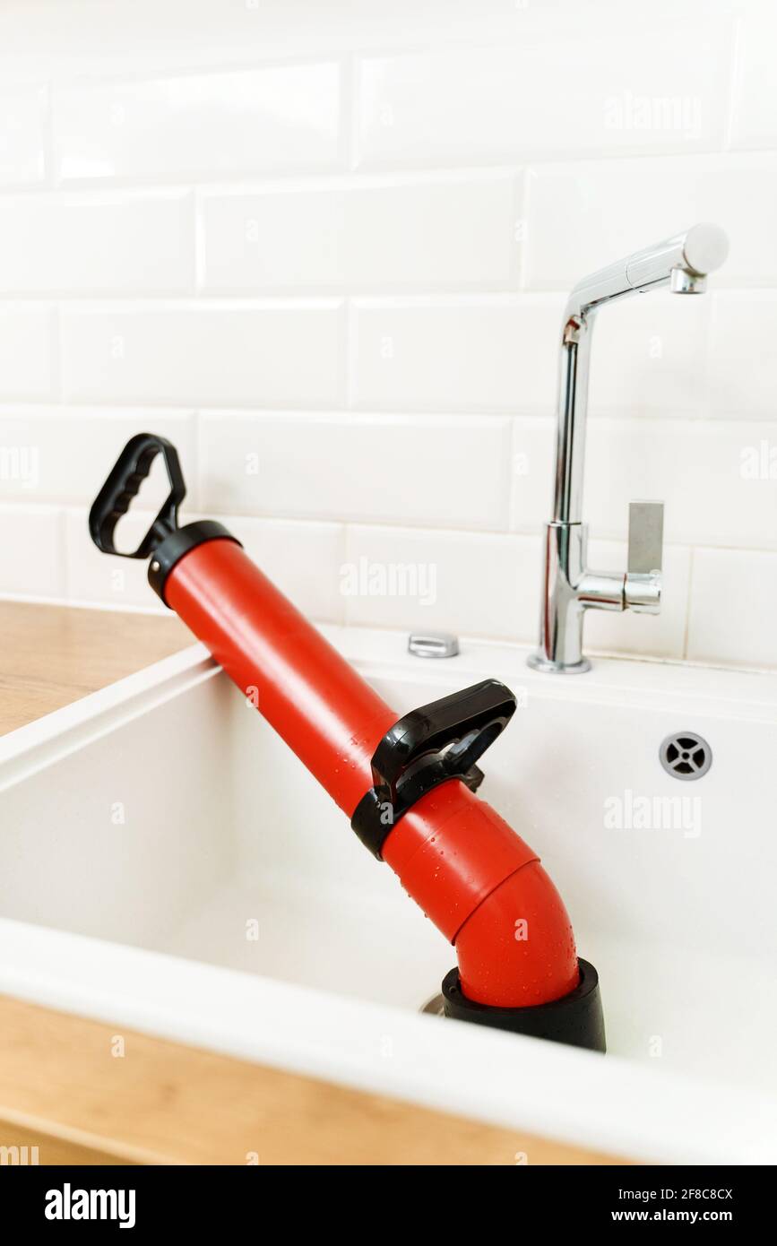Professional force pump cleaner in the kitchen sink. Stock Photo