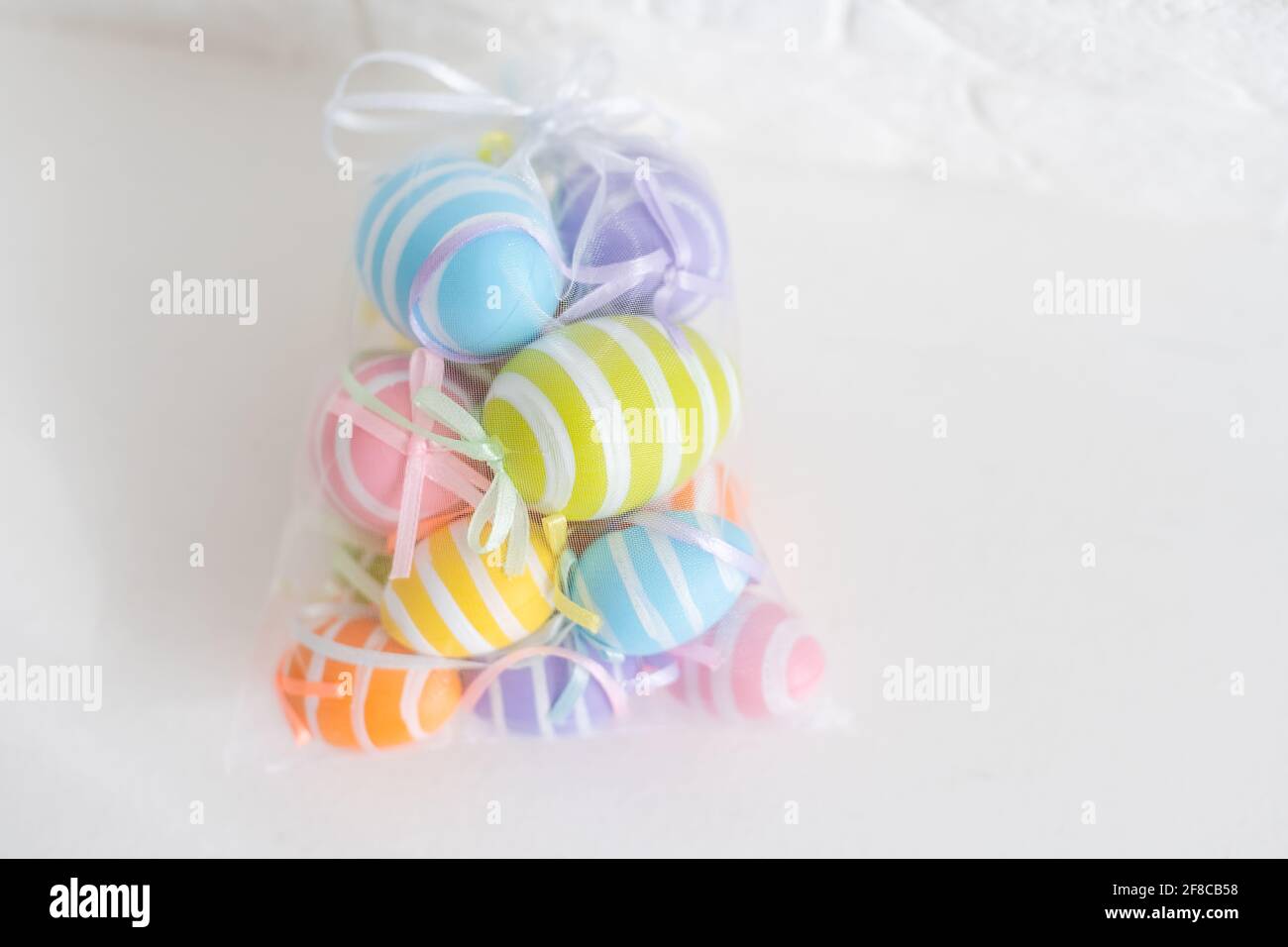 multi-colored chicken eggs in bag mesh on white background. easter Stock Photo