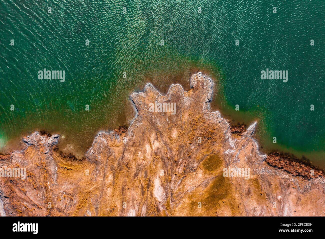 Aerial view about rocky seashore with turquoise waving water. Stock Photo
