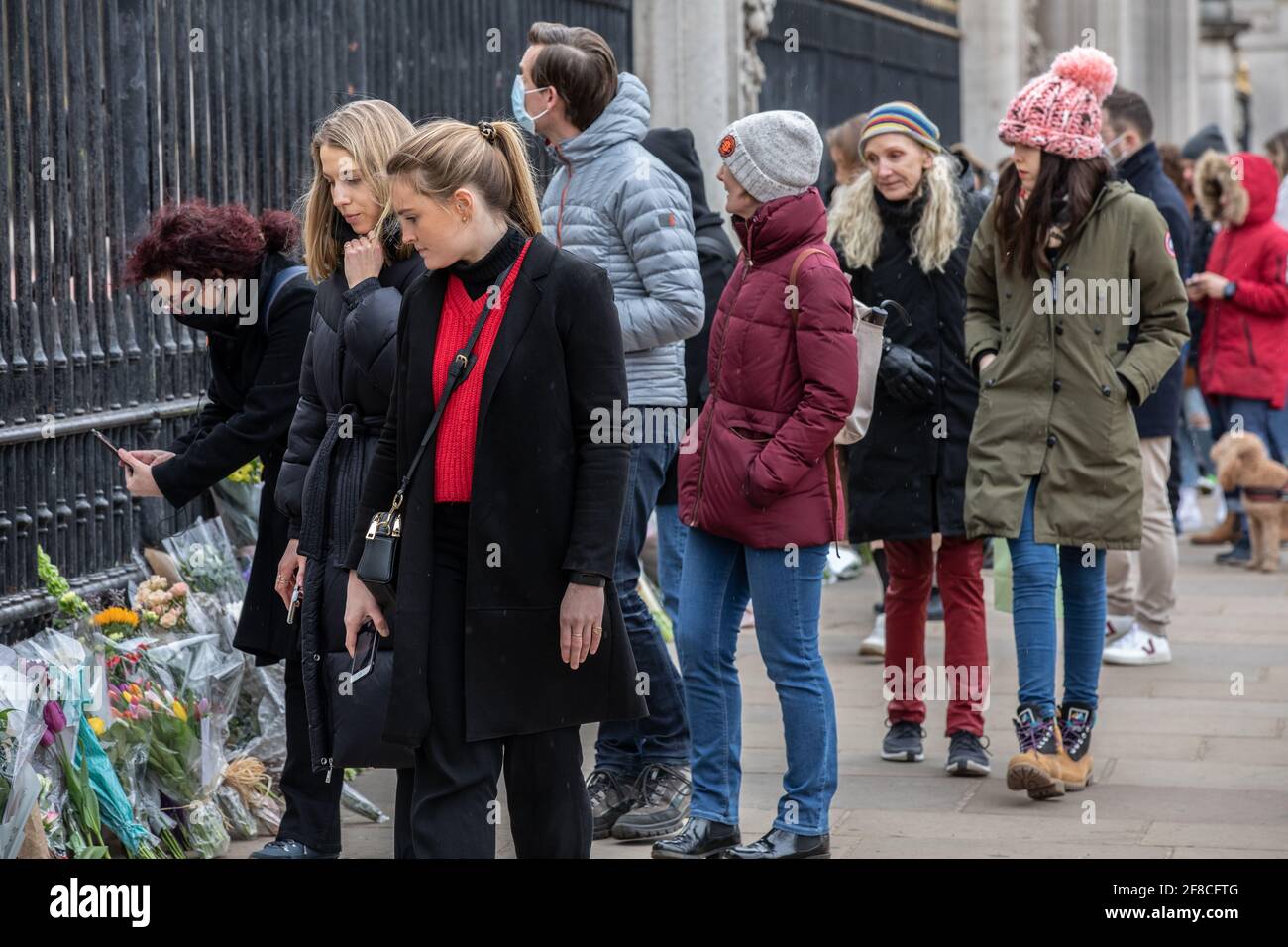 Well wishers queue to lay flowers to show their respects for Duke of Edinburgh outside Buckingham Palace after the Palace announced his death. Stock Photo