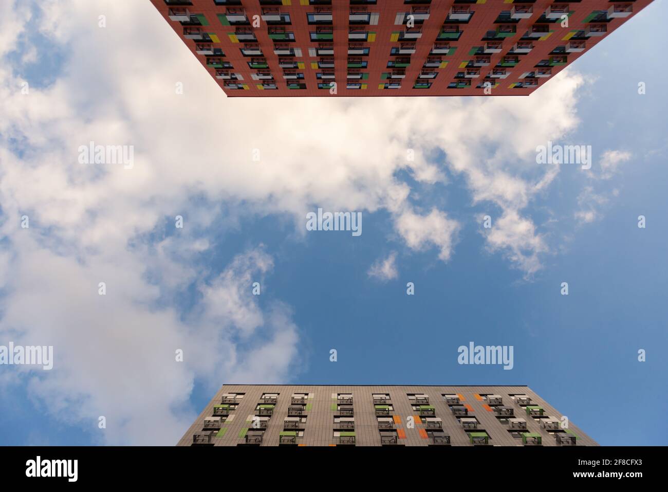 Two parallel houses with sky. Two tall towers and a sky with clouds between them. Stock Photo