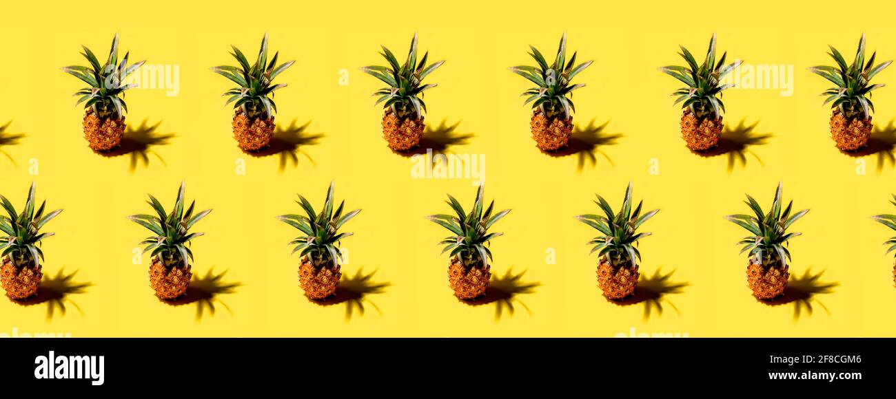 Many pineapples on a solid yellow background pattern Stock Photo