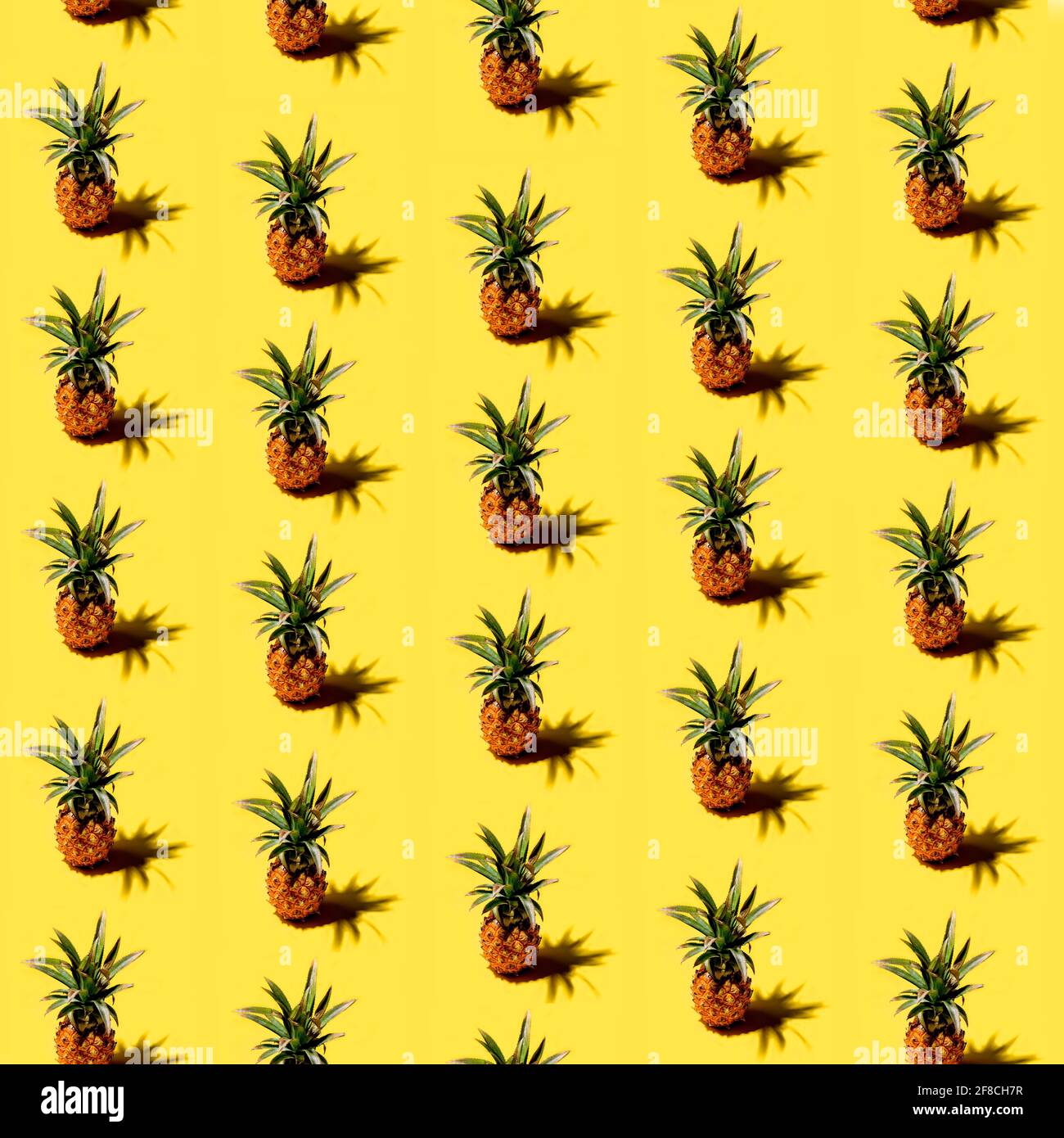 Many pineapples on a solid yellow background pattern Stock Photo