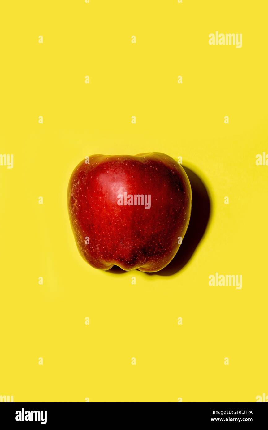Red apple on a solid yellow background Stock Photo