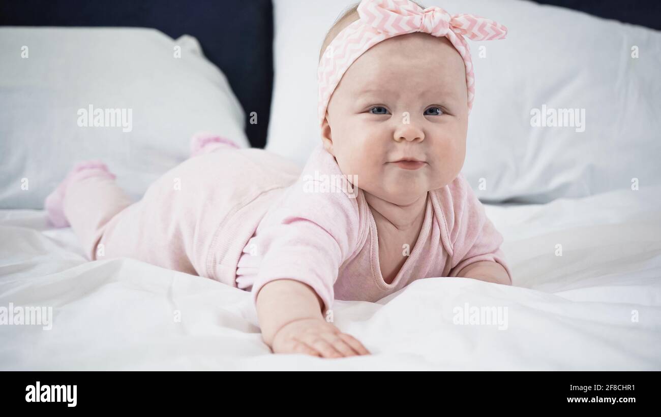 Baby girl lying on bed High Resolution Stock Photography and Images - Alamy
