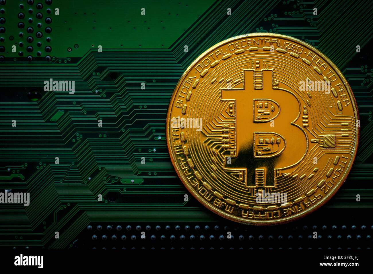 Golden coins with bitcoin symbol on green mainboard circuit background. Cryptocurrency, Money coin digital. Blockchain technology, bitcoin mining. Stock Photo