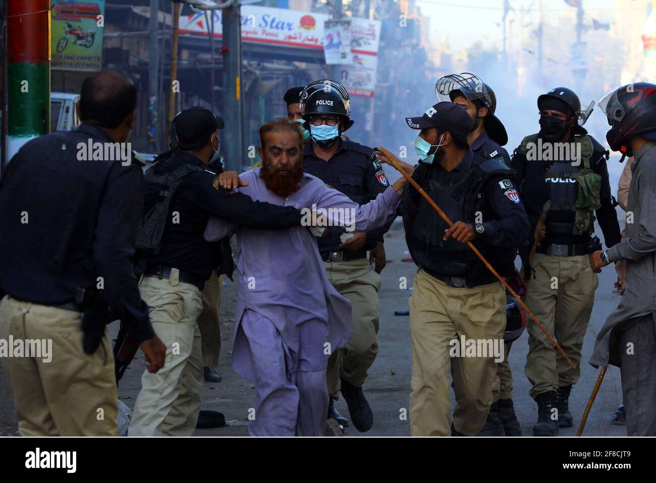 Police officials restore baton charge and fired tear gas shells to repel protesters during protest demonstration of Tehreek-e-Labbaik (TLP) against arrested of Saad Hussain Rizvi, Chief of Tehreek-e-Labbaik Pakistan (TLP) son of late cleric Khadim Hussain Rizvi, Baldia Town in Karachi on Tuesday, April 13, 2021. Stock Photo