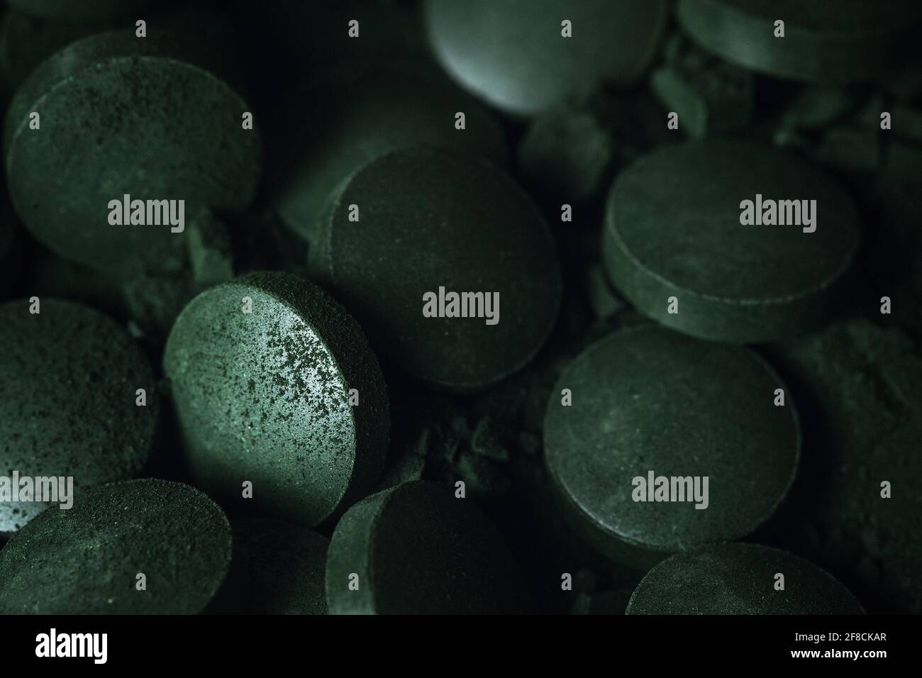 Spirulina powder and tablets algae. Macro close up. Stock Photo