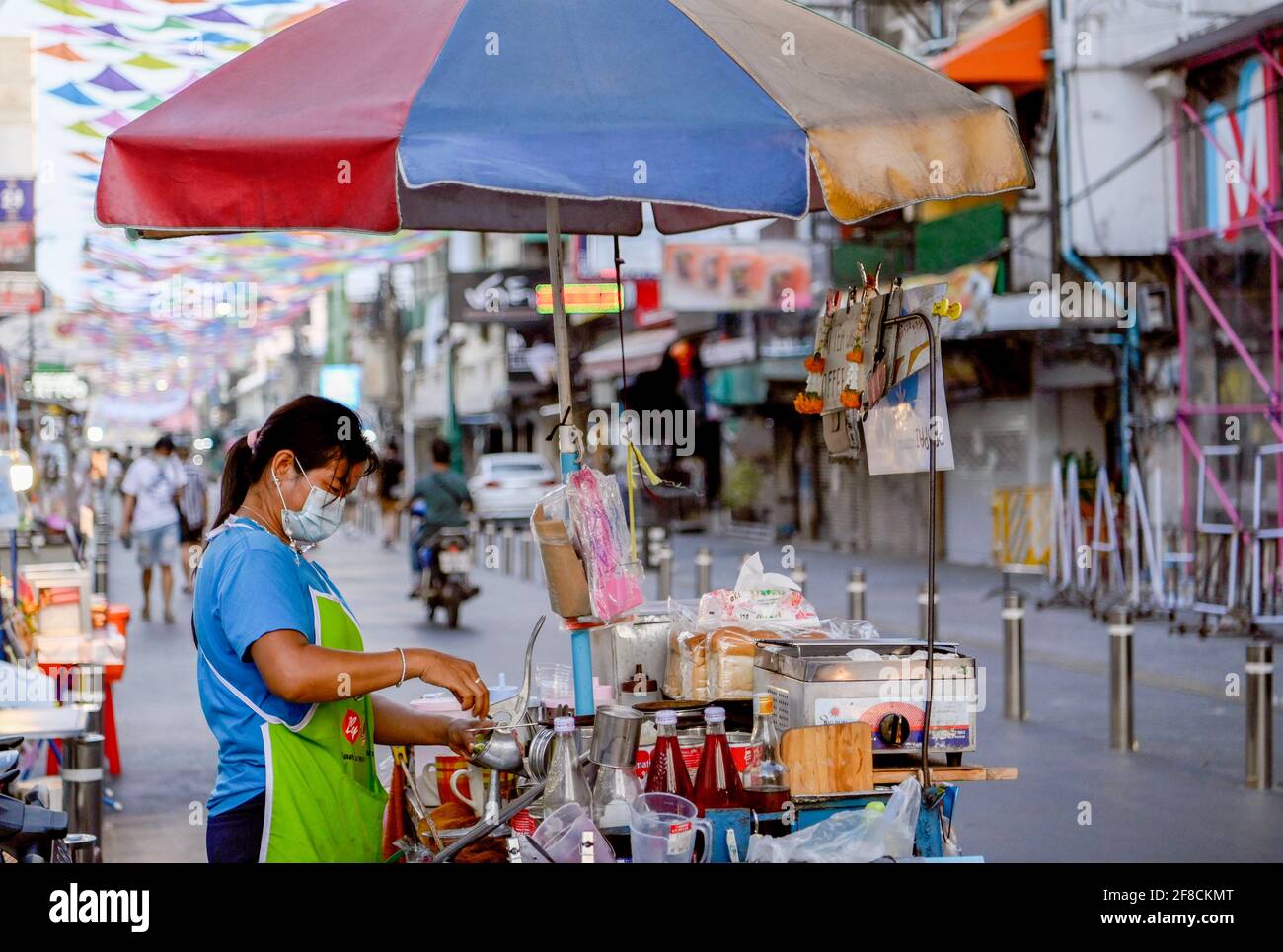 A vendor prepares food for sale on a  street during the Thai New Year Songkran holiday. Normally pre-pandemic covid -19, the street would be full of Thai and foreign tourists enjoying the celebration of the New Year harvest festival with water throwing and revelry. Bar and pubs are closed for 2 weeks during Songkran from April 6-19, 2021. (Photo by Paul Lakatos / SOPA Images/Sipa USA) Stock Photo