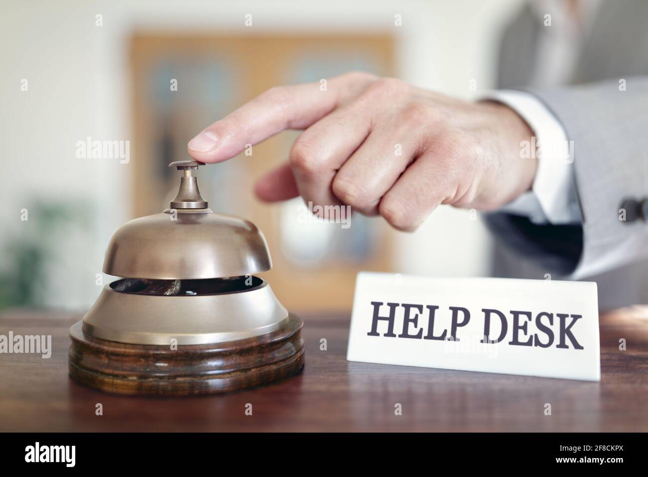Businessman ringing a help desk assistance service bell Stock Photo