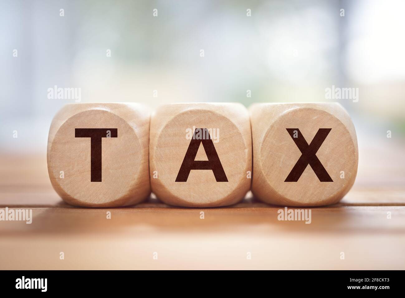 Tax written in wooden block letters background Stock Photo