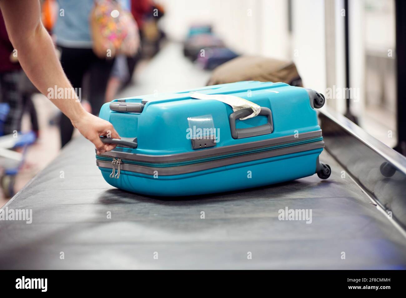 Suitcase on luggage conveyor belt carousel in the baggage claim at airport Stock Photo