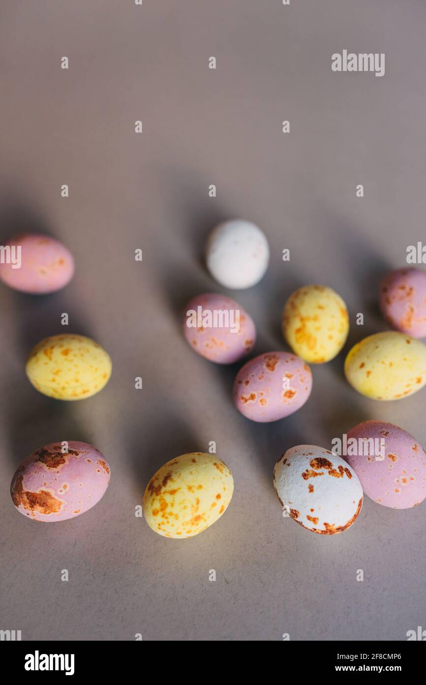 small colored chocolate eggs on a gray background Stock Photo