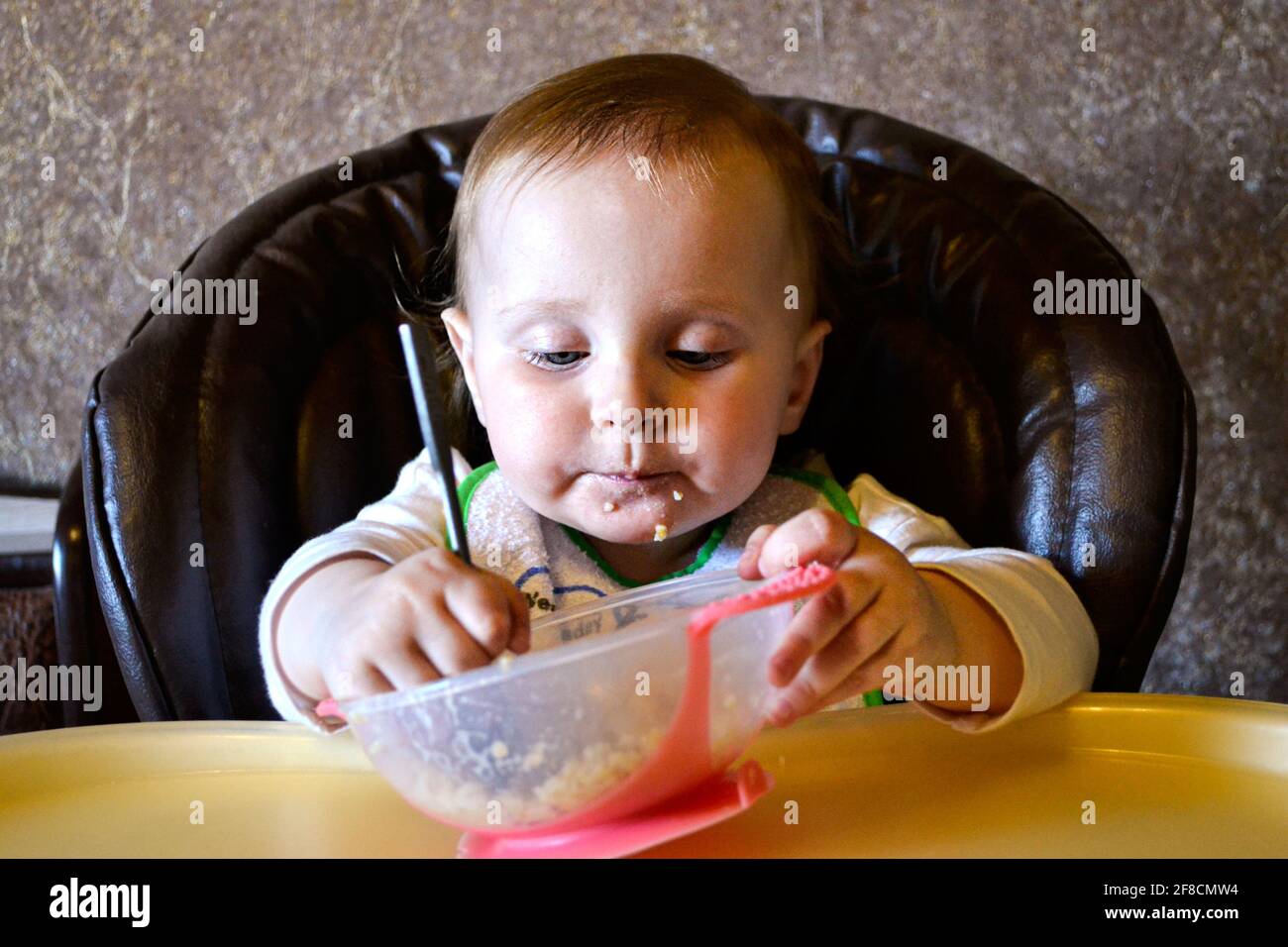 baby girl eating porridge from a bowl Stock Photo Alamy