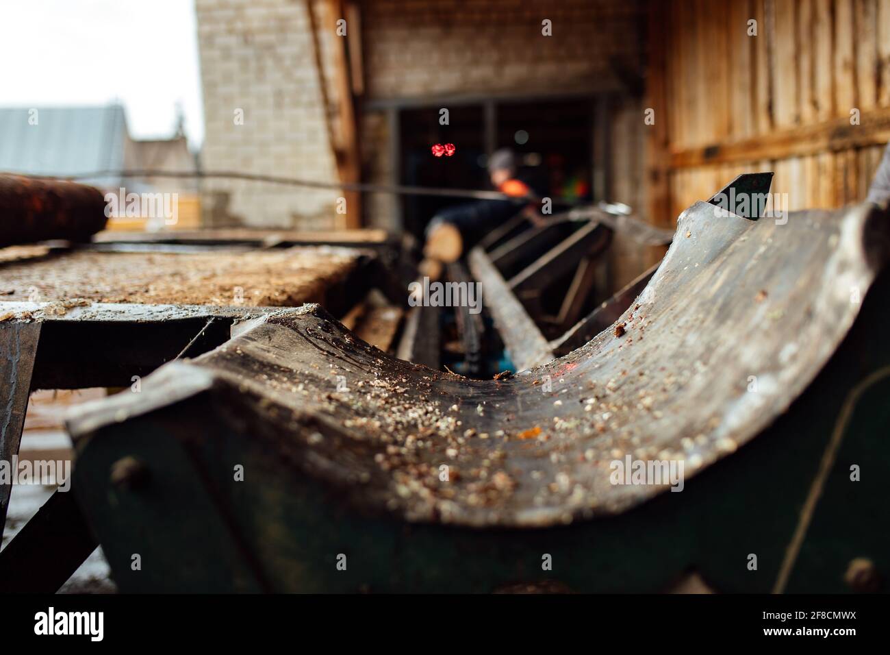 a log on a conveyor belt. transportation of wood raw materials at the plant. wood processing on a sawmill. automated conveyor Stock Photo