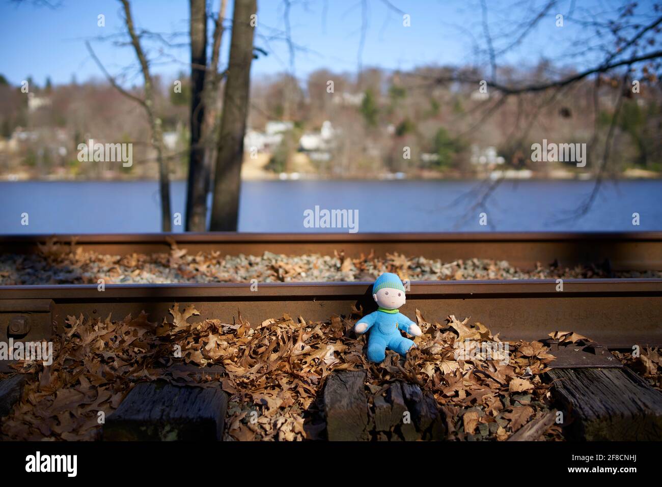 Lost toy doll next to train tracks. Stock Photo