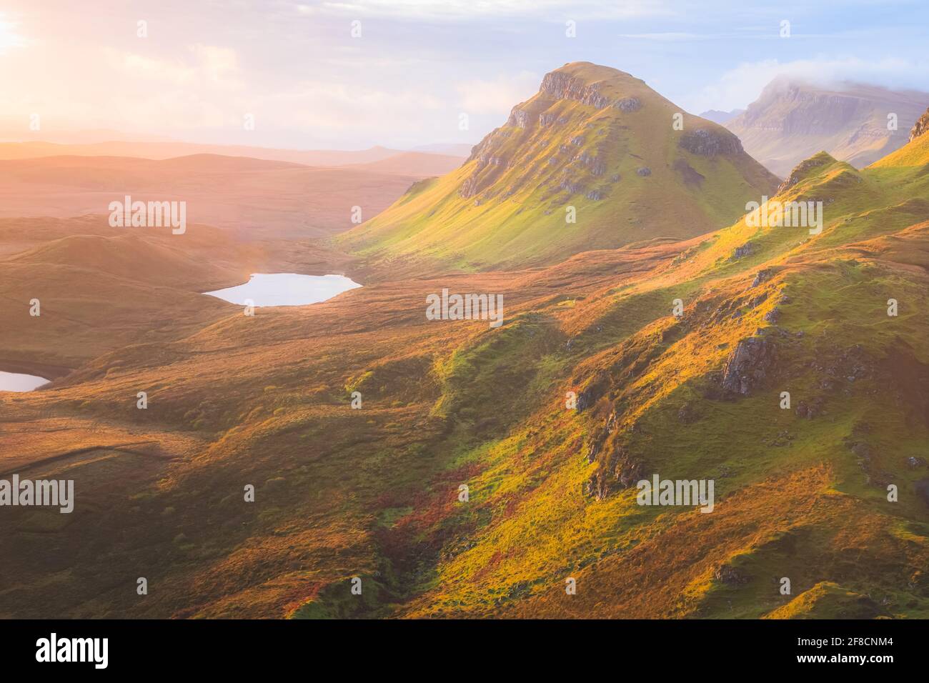 Vibrant golden light over epic mountain landscape of the rugged, contoured terrain of the Cleat at the Quiraing on the Isle of Skye, Scotland. Stock Photo