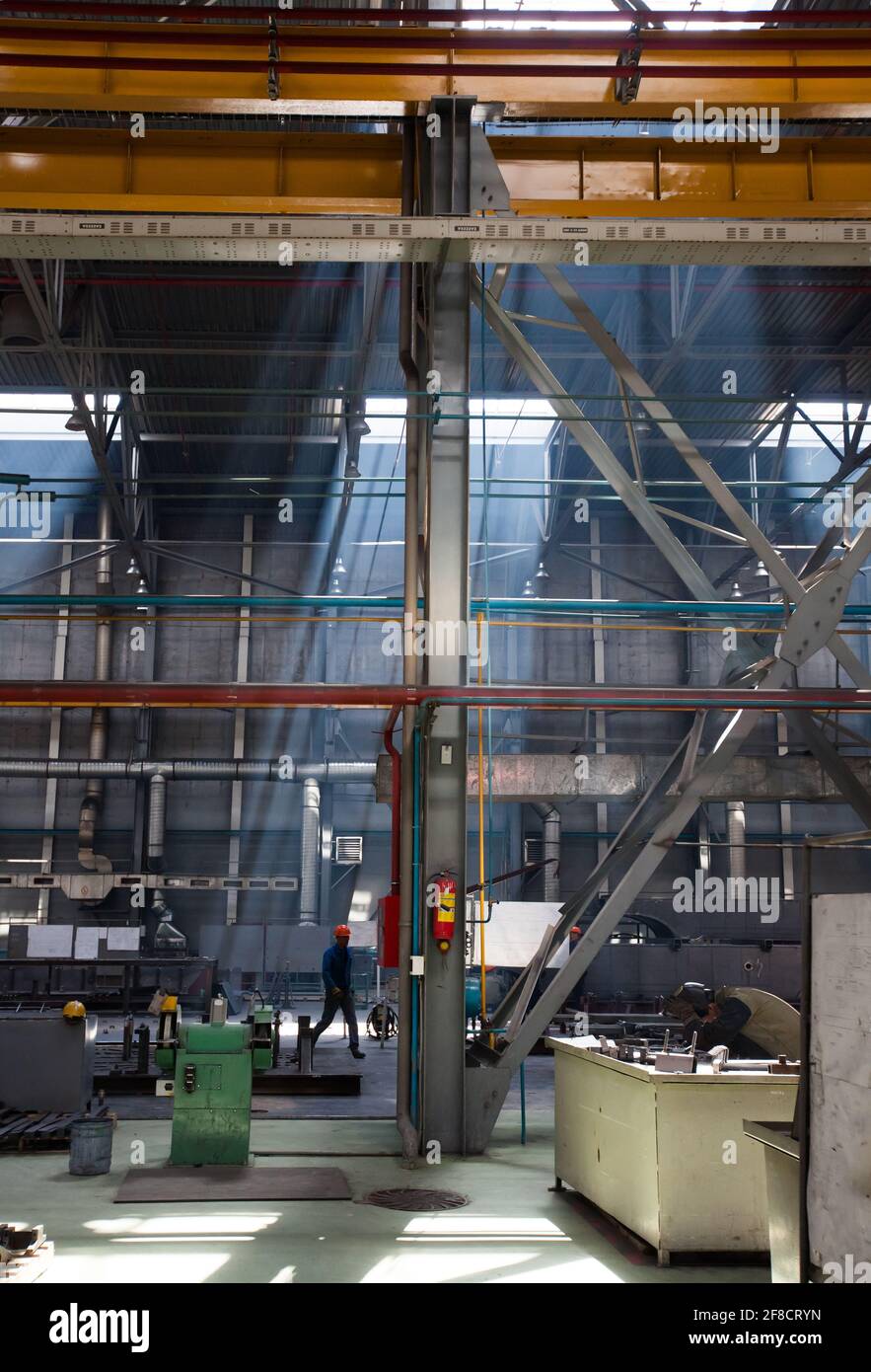 Kazakhstan, Nur-sultan. Locomotive-building plant workshop scene view. Smoke of welding and ray of light. Stock Photo