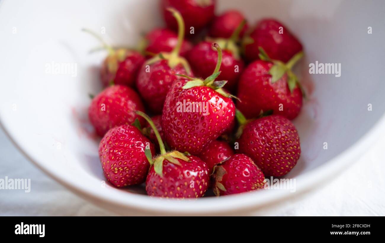Ripe, red strawberries in a white bowl Stock Photo