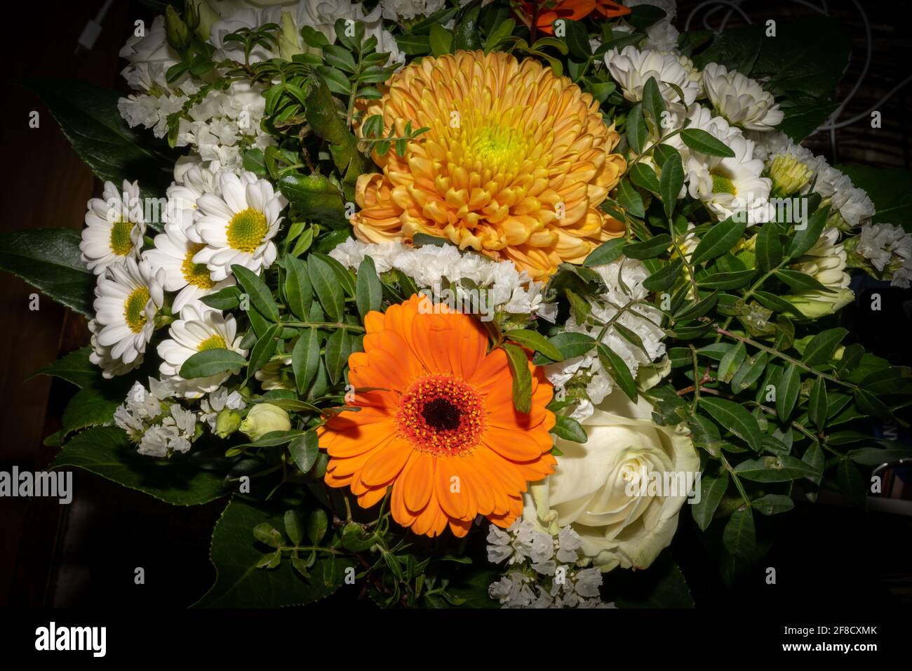 A closeup picture of a bouquet of funeral flowers. White, yellow and