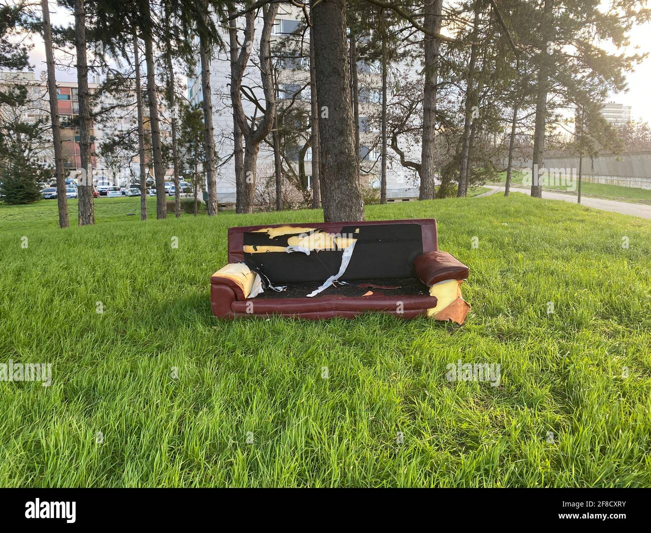 Waste Management - Damaged sofa thrown in the park carelessly. Improper waste disposal is one of the major problems all around the world. Stock Photo