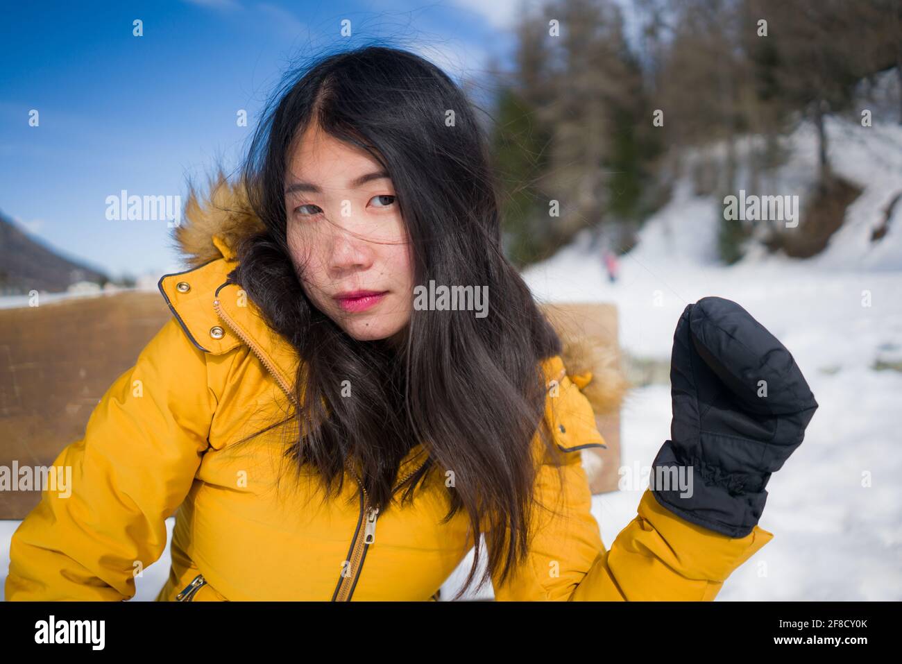 portrait of young cool and attractive Asian Japanese woman in yellow winter  jacket smiling cheerful on bench over frozen lake in snow at Swiss Alps mo  Stock Photo - Alamy