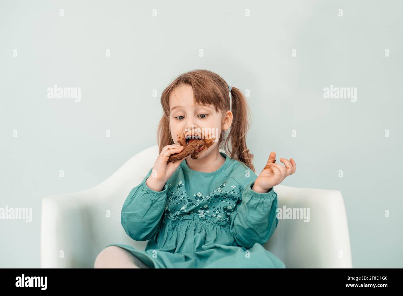 Adorable baby girl with face covered in chocolate Stock Photo