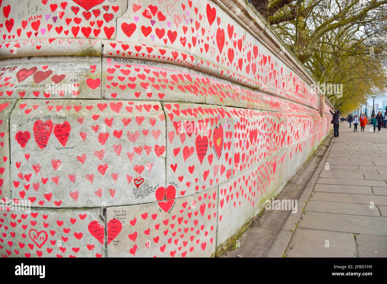 Red hearts on the National Covid Memorial Wall outside St Thomas' Hospital in London.150,000 red hearts have been painted by volunteers and members of the public, one for each life lost to Covid-19 in the UK to date. Stock Photo