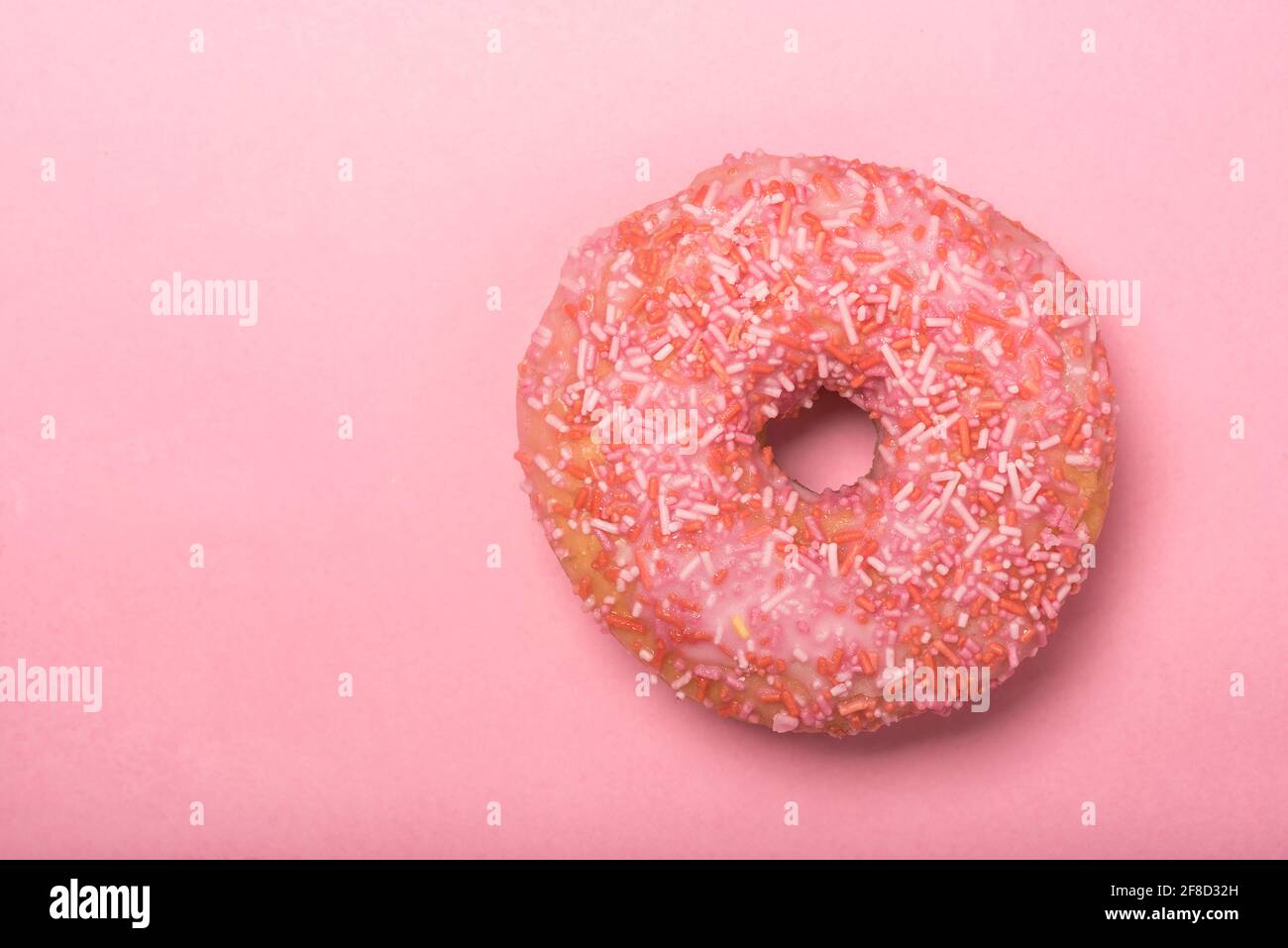 Colourful iced ring doughnuts with sprinkles. Stock Photo
