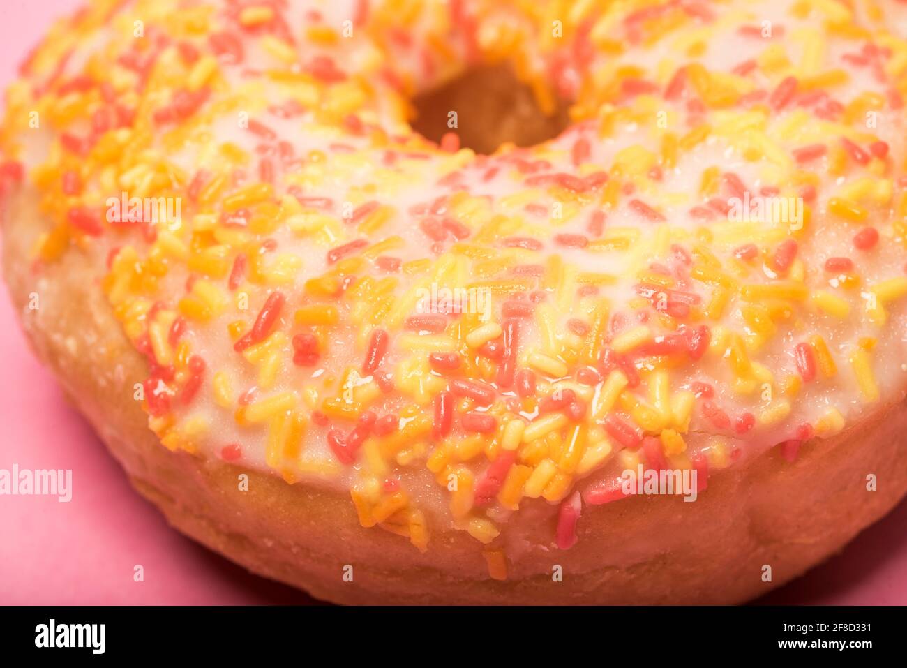 Close up of a colourful iced ring doughnut with sprinkles Stock Photo