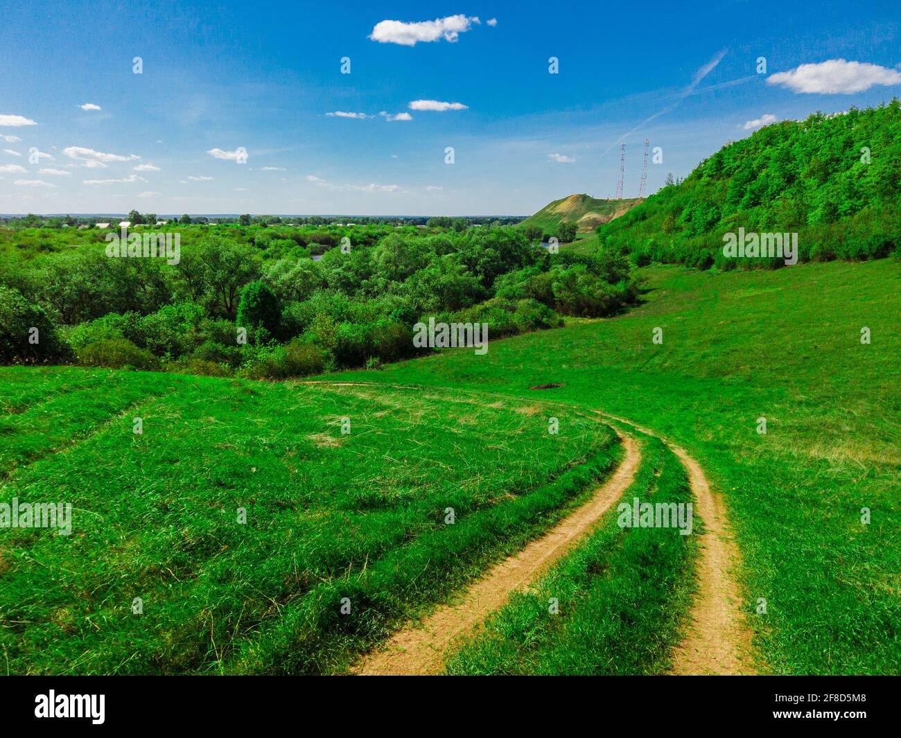 Road in green field and blue sky with clouds Stock Photo - Alamy
