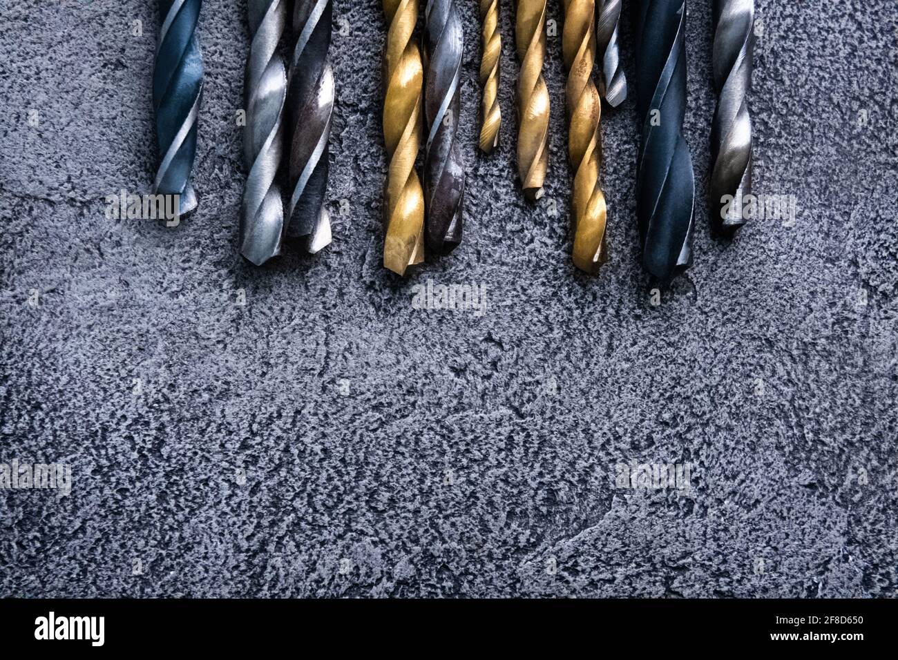 Different sizes drill bits on grey background with copy space Stock Photo