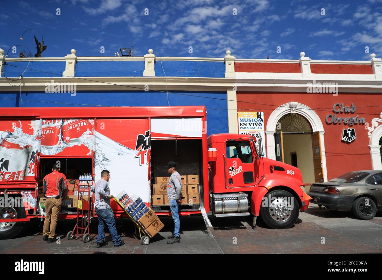 A delivery truck from the Cuatemoc Moctezuma or Tecate brewery sells cans  and cartons of beer in a blue building called Cerveceria la Barra Hidalgo  in the historic center of Hermosillo, Sonora,