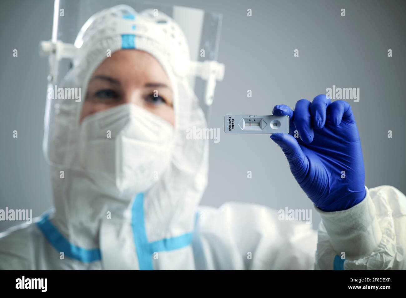 Doctor or nurse in protective face mask and gloves holding negative COVID-19 test. Diagnosis of coronavirus, Inhibition of disease outbreaks. Stock Photo