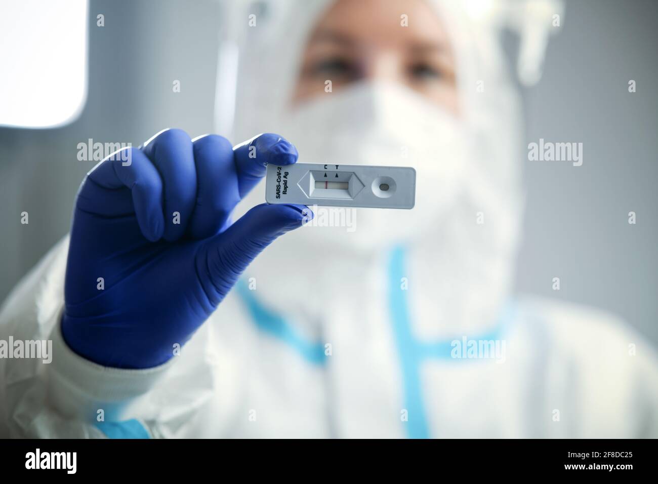 Doctor or nurse in protective face mask and gloves holding negative COVID-19 test. Diagnosis of coronavirus, Inhibition of disease outbreaks. Stock Photo