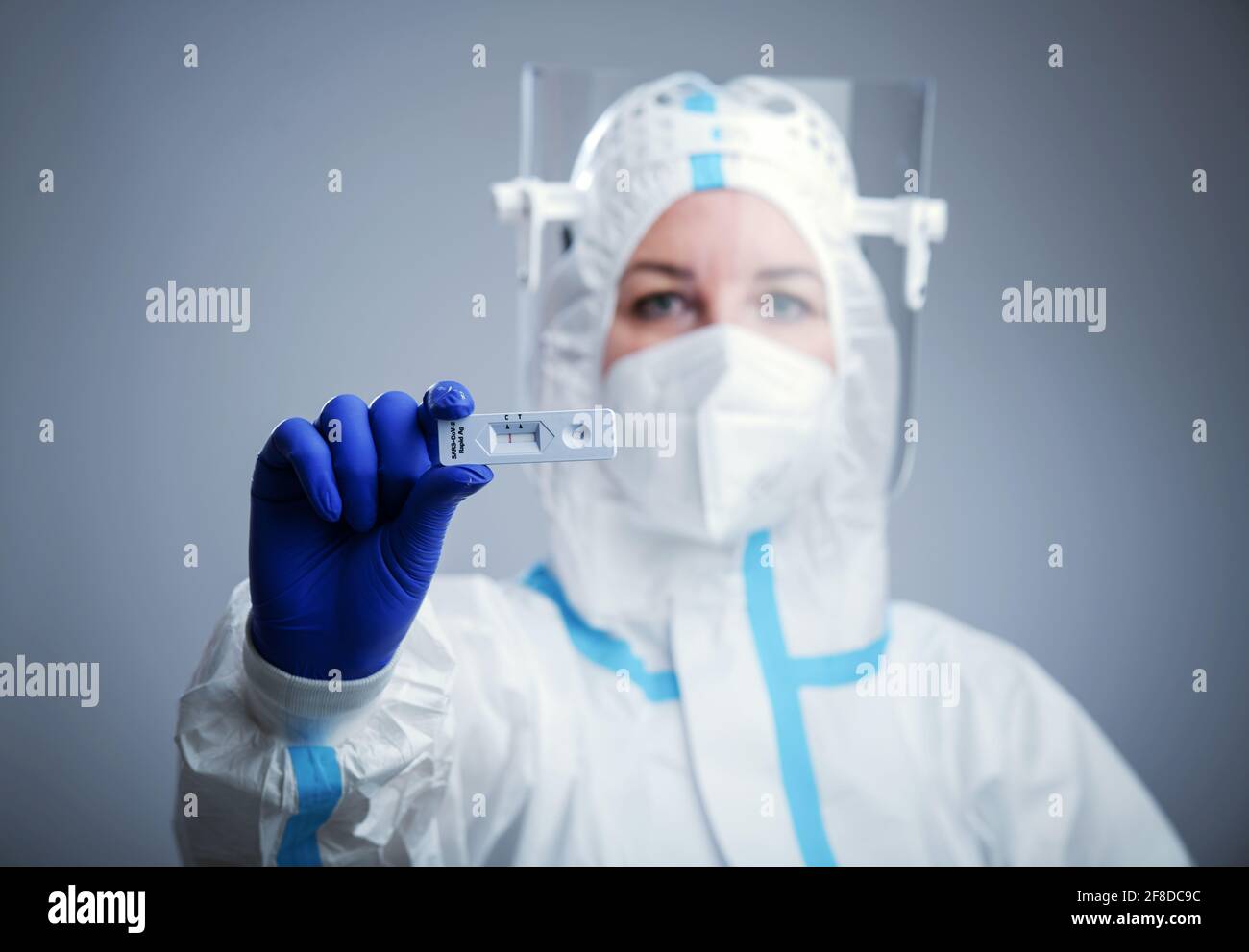 Doctor or nurse in protective face mask and gloves holding negative COVID-19 test. Diagnosis of coronavirus, Inhibition of disease outbreaks. Stock Photo