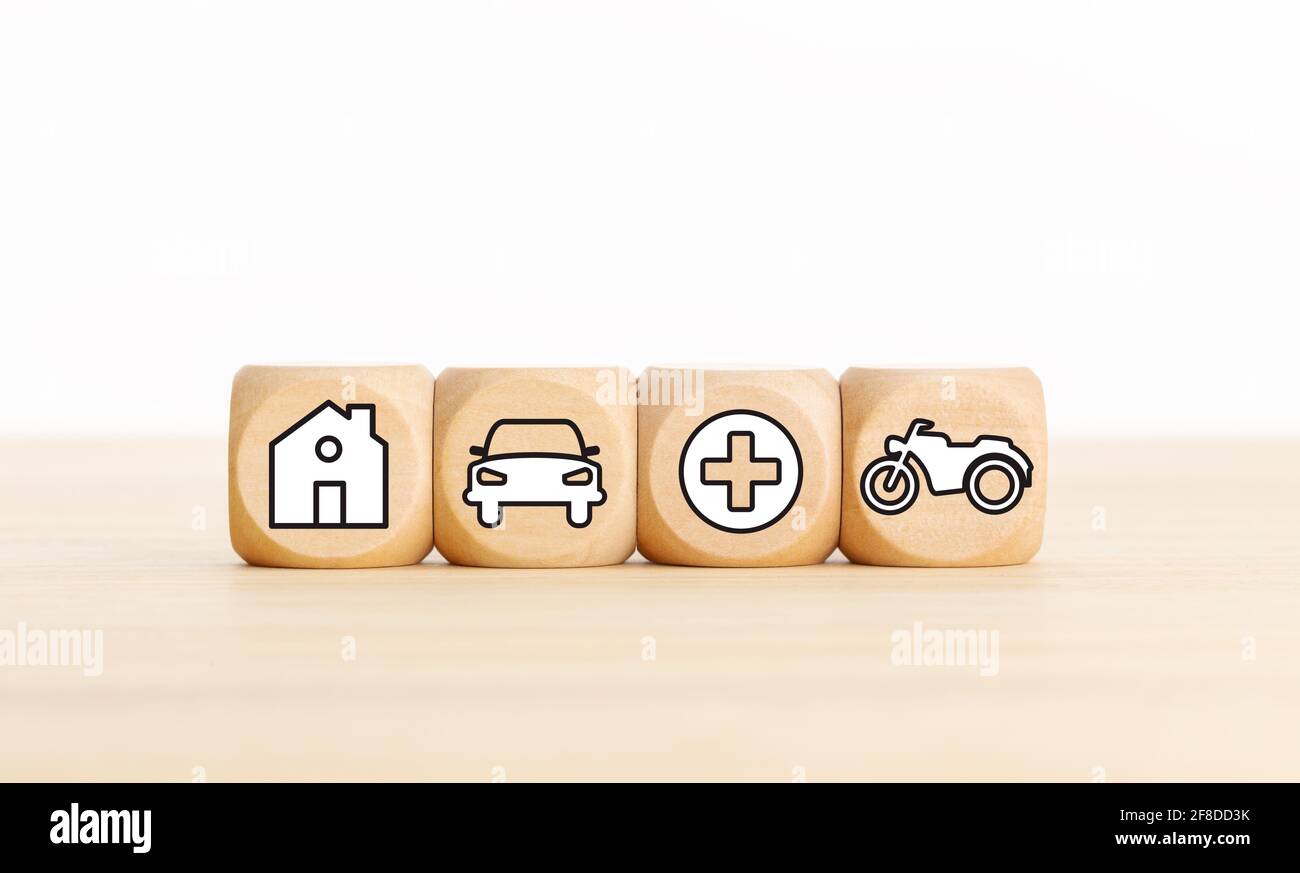 House, car, health and bike icons on wooden blocks Types of insurance concept. Copy space Stock Photo
